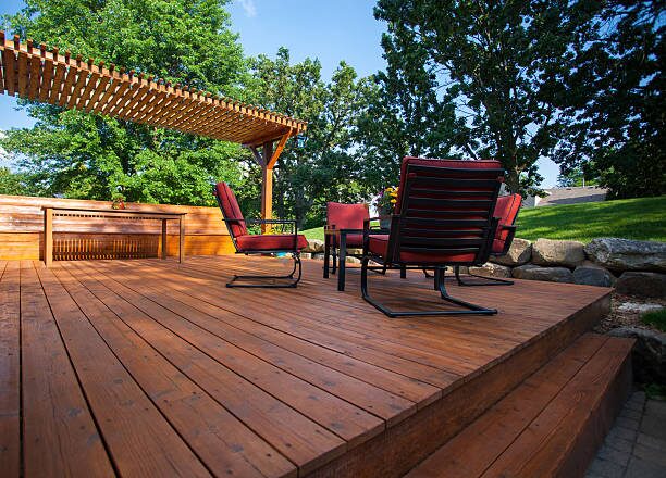 Freshly stained backyard wood deck with pergola and outdoor seating by a painting company in Worthington, OH