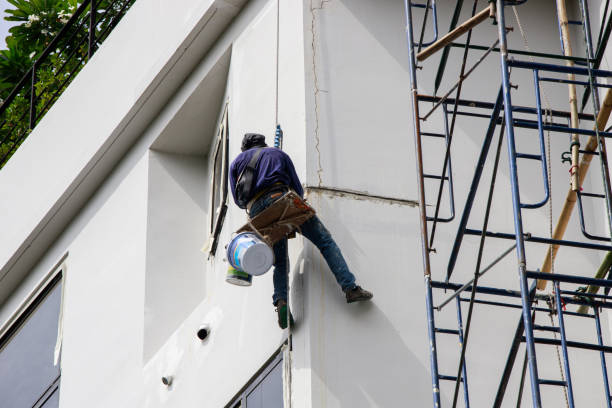 A professional painting contractor working on a commercial building exterior by a painting company in Powell, OH.